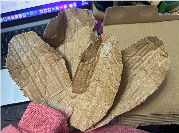 Groupmember are cutting the petal shape out of cardboard.
